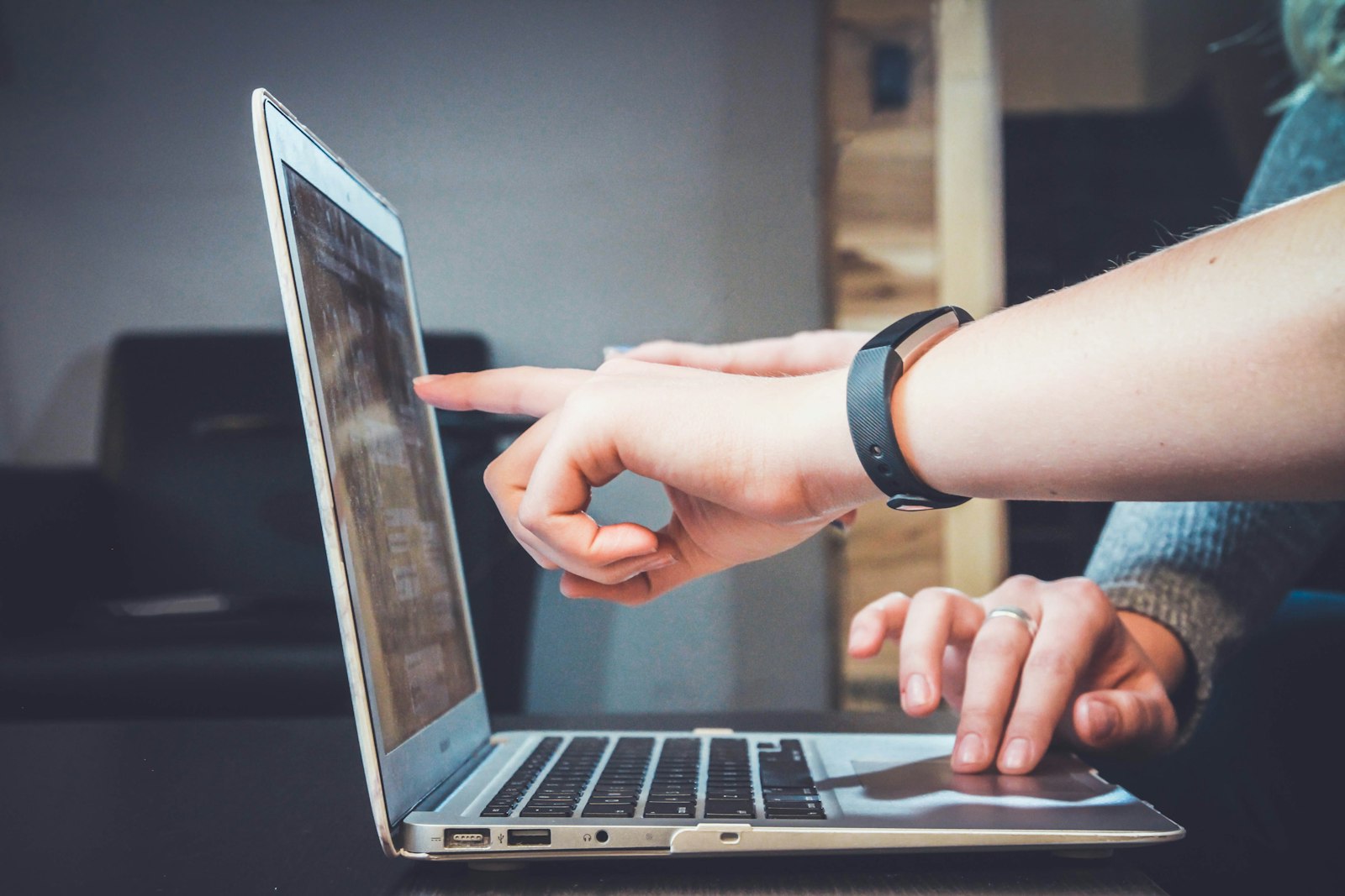 Mentor pointing at a laptop screen while a developer types